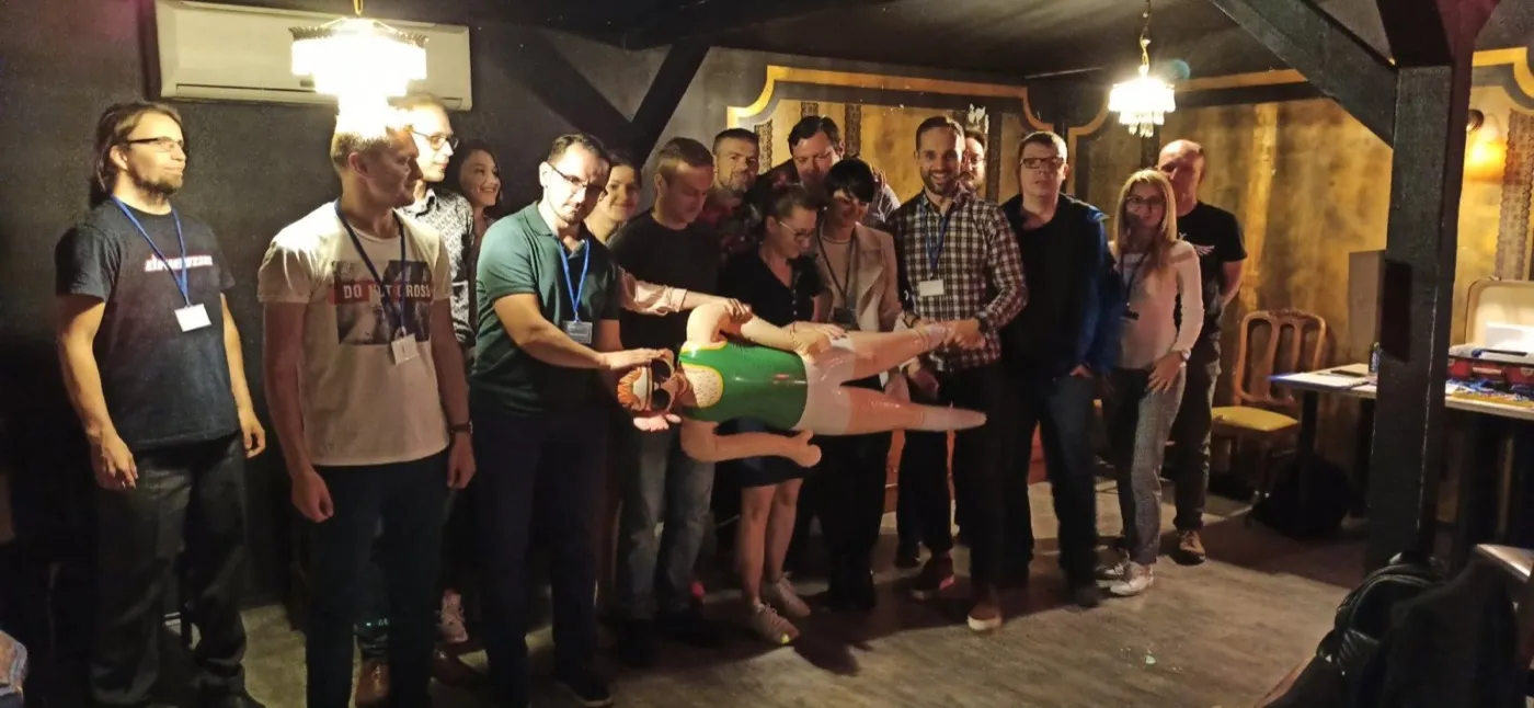 Klubowicze pozują do wspólnego zdjęcia w sali z drewnianym stropem